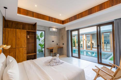 a bedroom with a bed and a view of a pool at J4 Villas Sanur in Sanur