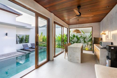a kitchen and living room with a swimming pool at J4 Villas Sanur in Sanur