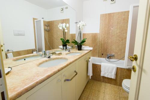 a bathroom with two sinks and a tub and a toilet at Italianflat - Palazzo Zeiner in Verona