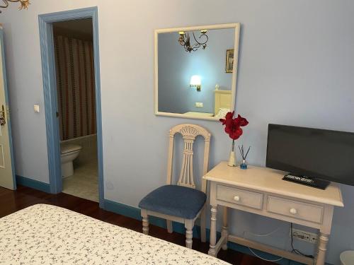 a bedroom with a desk and a mirror and a chair at Hotel Kaia in Ciérvana