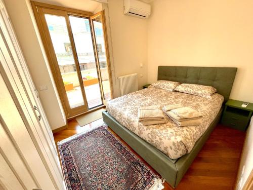 sypialnia z łóżkiem i dużym oknem w obiekcie Via Umbria 25 Luxury Suites w Rzymie