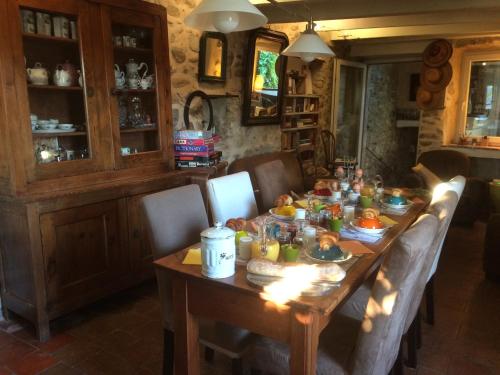 - une table en bois avec de la nourriture dans l'établissement Chambres du clocher, à Vallon-Pont-dʼArc