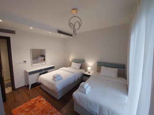 Cette chambre comprend 2 lits et un miroir. dans l'établissement CFC, Luxurious 4BR Apartment, Remarkable value unbeatable Location, au Caire