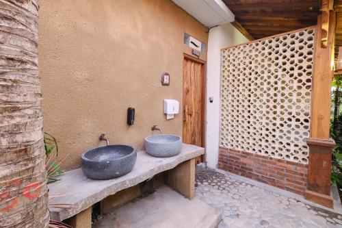 ein Badezimmer mit zwei Waschbecken auf einer Terrasse in der Unterkunft Green Bali Guest House in Munggu