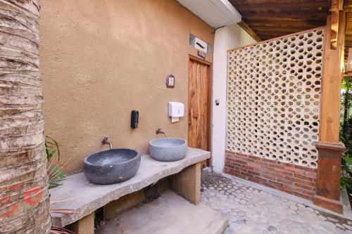 a bathroom with two sinks on a patio at Green Bali Guest House in Munggu
