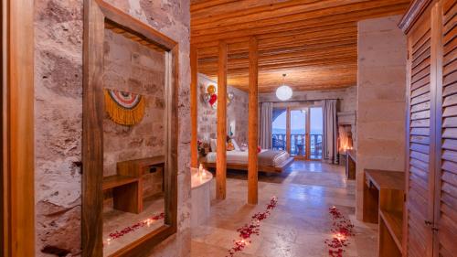 1 dormitorio con 1 cama y chimenea en una habitación en La Fairy Cappadocia Adult Only, en Uchisar