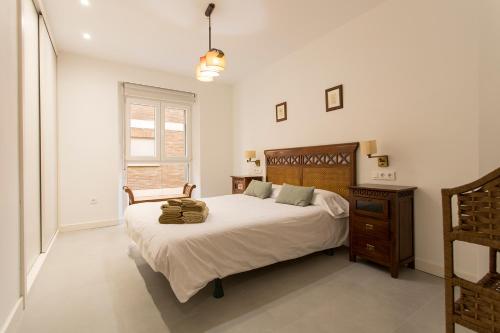 um quarto com uma cama grande e uma cabeceira em madeira em Apartamento Mulhacen Centro em Granada
