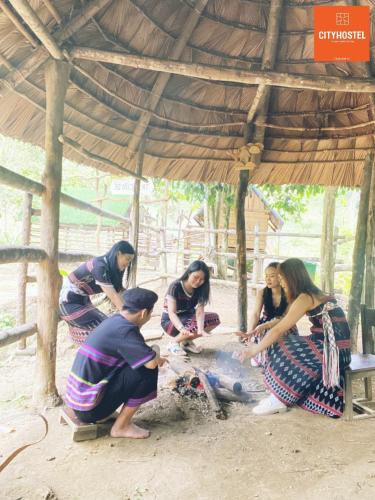 a group of people standing around a grill at City Hostel Da Nang in Da Nang