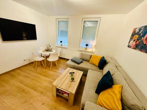 una sala de estar con un sofá y una mesa en FeWo Kastanie mit Balkon #Netflix #Innenstadtnähe von Harztraveler, en Bad Harzburg