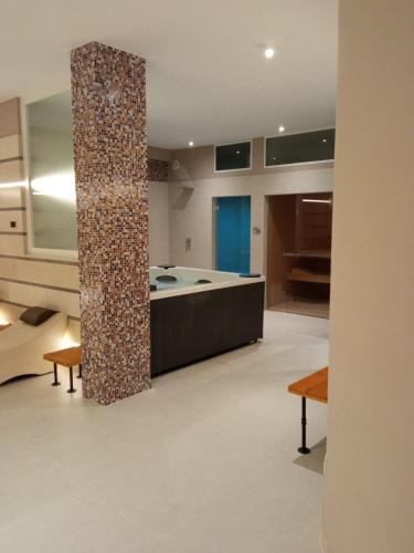 a room with a bathtub and a pillar in the middle at B&B "Corte Mopps" Grottaglie città della ceramica - SPA Elysium in Grottaglie