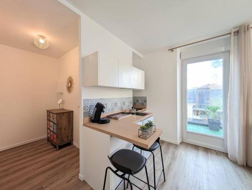 - une cuisine avec un comptoir et deux tabourets dans une pièce dans l'établissement Plage et commerces de Pornichet - Appt 3 personnes, à Pornichet