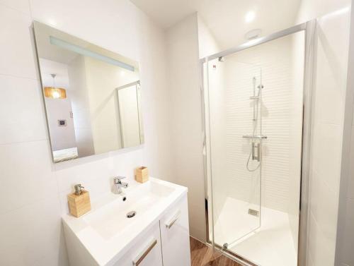 une salle de bain blanche avec un lavabo et une douche dans l'établissement Plage et commerces de Pornichet - Appt 3 personnes, à Pornichet