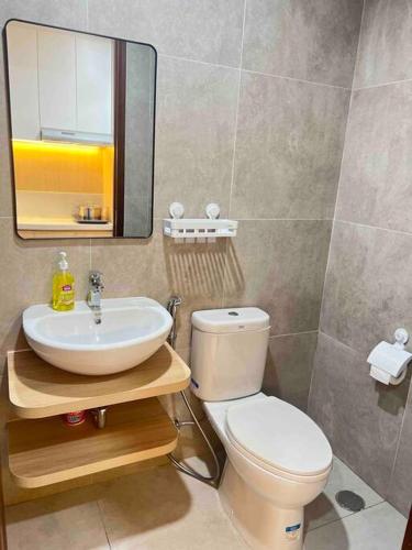 La salle de bains est pourvue de toilettes, d'un lavabo et d'un miroir. dans l'établissement Wawa Guesthouse Pollux Habibie Batam Tower A 17, à Kangboi
