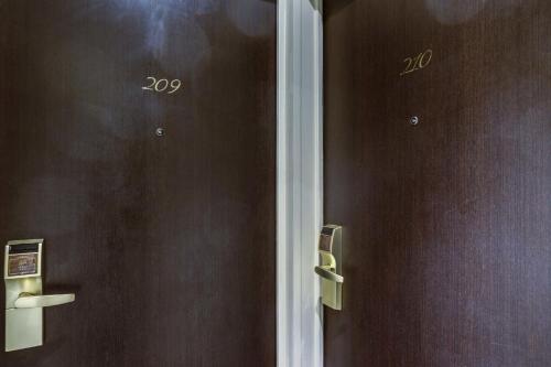 two brown doors with numbers on them at Hôtel Paris Louvre Opéra in Paris