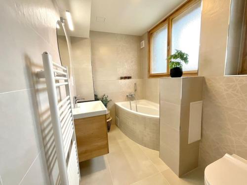 ein Badezimmer mit einer Badewanne, einem Waschbecken und einem WC in der Unterkunft Apartmán č.4 v bankovním domě in Kutná Hora