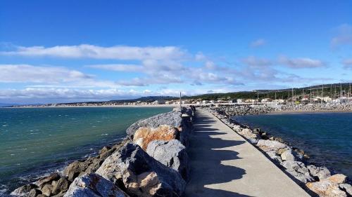 a walkway leading to the ocean on a beach at Charmant mobil-home 97 in Narbonne