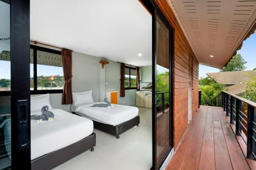 two beds in a room with a balcony at Chill Inn Samui Hostel and Restaurant in Koh Samui 