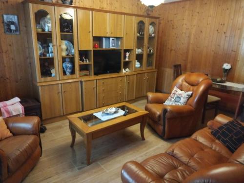 ein Wohnzimmer mit Ledersesseln und einem Couchtisch in der Unterkunft A casa de Dora da Estrada in A Estrada