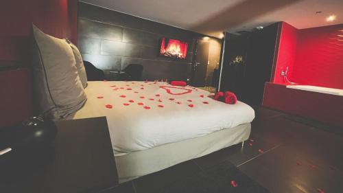 a bedroom with a bed with red rose petals on it at Le Confiden'spa Loft 55m2 Jacuzzi - Billard - Cheminée - Terrasse in Hoenheim