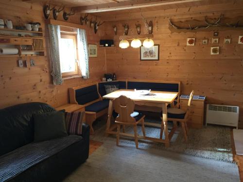ein Wohnzimmer mit einem Tisch, Stühlen und einem Sofa in der Unterkunft FELBER Hüttn in Patergassen