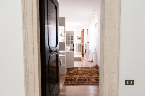 a hallway with a black door and a rug at Italianflat - Palazzo Zeiner in Verona