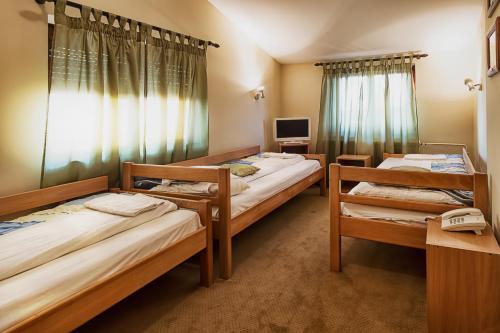 een kamer met drie bedden en een televisie bij Apartments & Rooms - Konak Vukasinovic in Belgrado