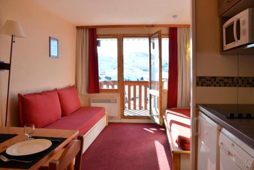 un petit salon avec un canapé et une table dans l'établissement Appartement avec vue et accès skis aux pieds., à La Plagne Tarentaise