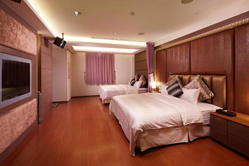 薇風情汽車旅館 - 台南館 في Liujia: غرفة فندقية بسريرين وتلفزيون بشاشة مسطحة