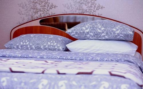 ein Bett mit blauen und weißen Kissen darauf in der Unterkunft VIP apart 482 in Tbilisi City