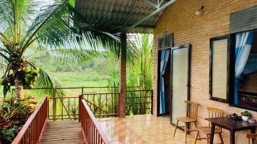 a porch with a table and chairs on a balcony at Gibbon Singing Home Stay in Quan Tom