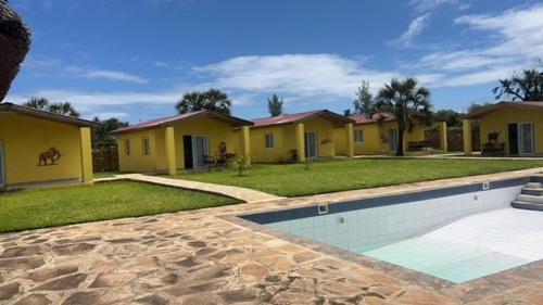 uma fila de casas amarelas com piscina em Coral Villas Cottage em Ukunda