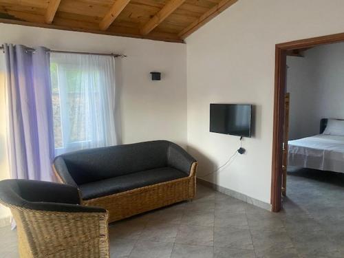 ein Wohnzimmer mit einem Sofa und einem Bett in der Unterkunft Coral Villas Cottage in Ukunda