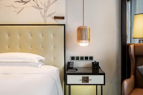 a bedroom with a bed and a side table with a lamp at Hilton Shenzhen Futian, Metro Station at Hotel Front Door, Close to Futian Convention & Exhibition Center in Shenzhen