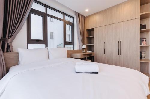 a bedroom with a large white bed and a window at Westlake Emerald Suites in Hanoi
