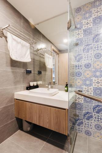a bathroom with a sink and a shower at Westlake Emerald Suites in Hanoi