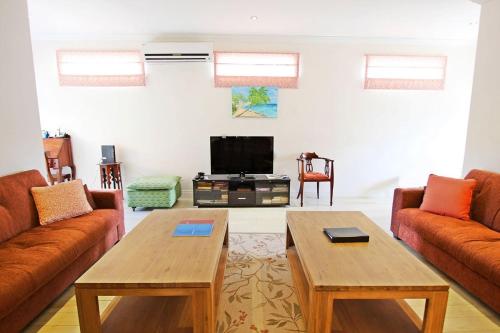 Una sala de estar con dos sofás y un televisor. en Arcadia Blue Sky Luxury, en Bridgetown
