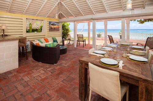 una sala da pranzo con tavolo e vista sull'oceano di Arcadia Blue Sky Luxury a Bridgetown