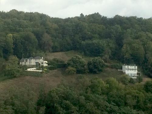 a house on top of a hill with trees at Le PANORAMA Maison Blanche in Tulle