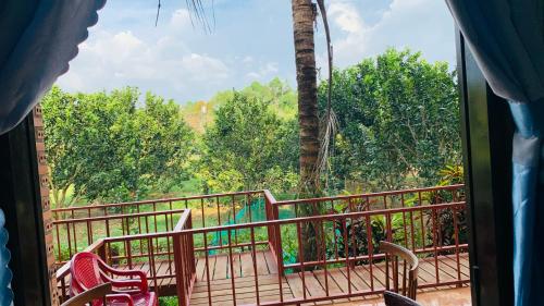a balcony with chairs and a view of a forest at Gibbon Singing Home Stay in Quan Tom