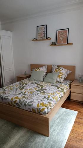 - une chambre avec un grand lit et un cadre en bois dans l'établissement Appartement au coeur de paris à 1 kilomètre de la Tour Eiffel, à Paris