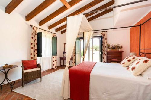 um quarto com uma cama, uma cadeira e uma janela em Monte da Pedra Torta em Redondo