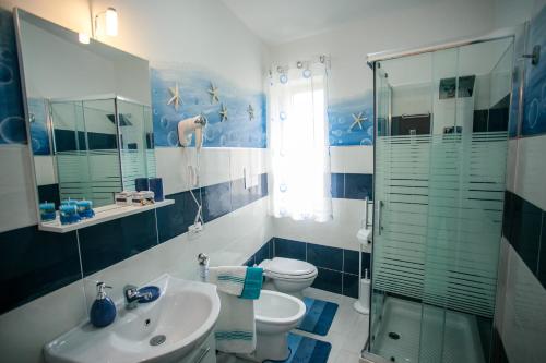 een badkamer met een wastafel, een toilet en een douche bij La casa del pescatore in Oliveri