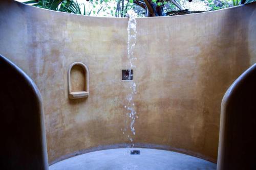una fuente de agua en medio de una pared en PEARL STAR BEACH RESORT, en Alankuda