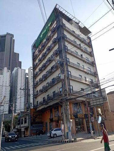 een hoog gebouw in een stadsstraat met auto's bij St. Marvin Studio Makati M409 in Manilla