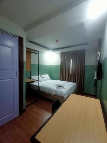 een kleine kamer met een bed en een tafel bij St. Marvin Studio Makati M409 in Manilla