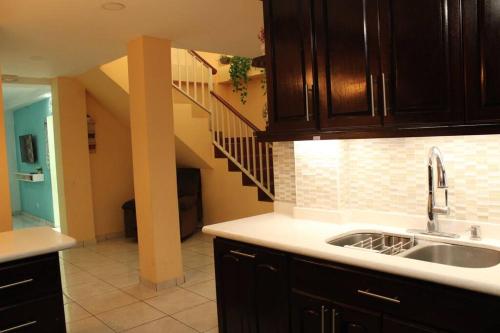 a kitchen with a sink and a staircase at Casa grande de 4 niveles, cerca de Metrocentro in Santa Ana