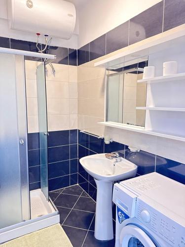 La salle de bains est pourvue d'un lavabo et d'un lave-linge. dans l'établissement Deep Blue Sea View Apartments, à Saranda