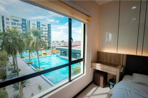 a bedroom with a view of a pool from a window at Waterpark Ipoh Manhattan 3BR 8pax Condo Vacation Home by City Home Empire in Ipoh