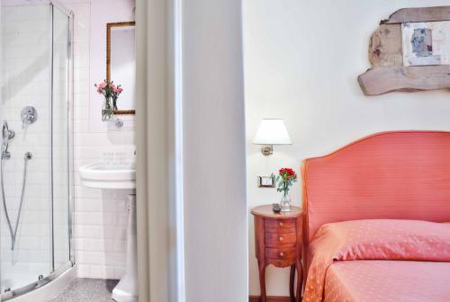 sypialnia z łóżkiem oraz łazienka z umywalką w obiekcie Casa De' Fiori w Rzymie