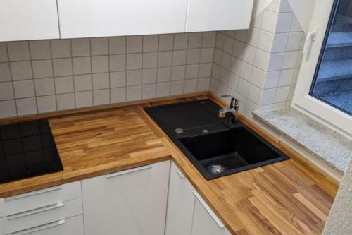 een kleine keuken met een wastafel en een raam bij NEU! Moderne Ferienwohnung Ulm in Ulm